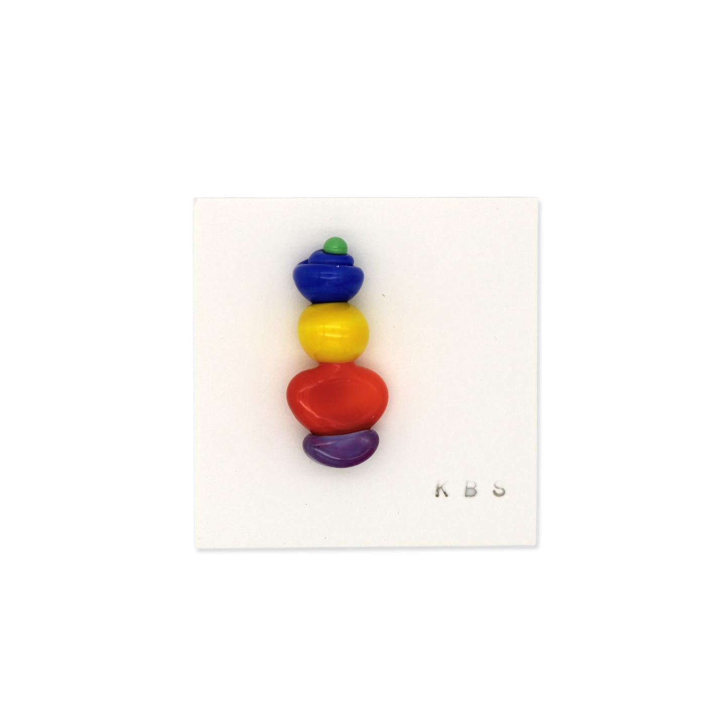 Colorful glass pin/brooch by Krista Bermeo Studio - green, blue, yellow, orange, and purple stacked abstract shapes.