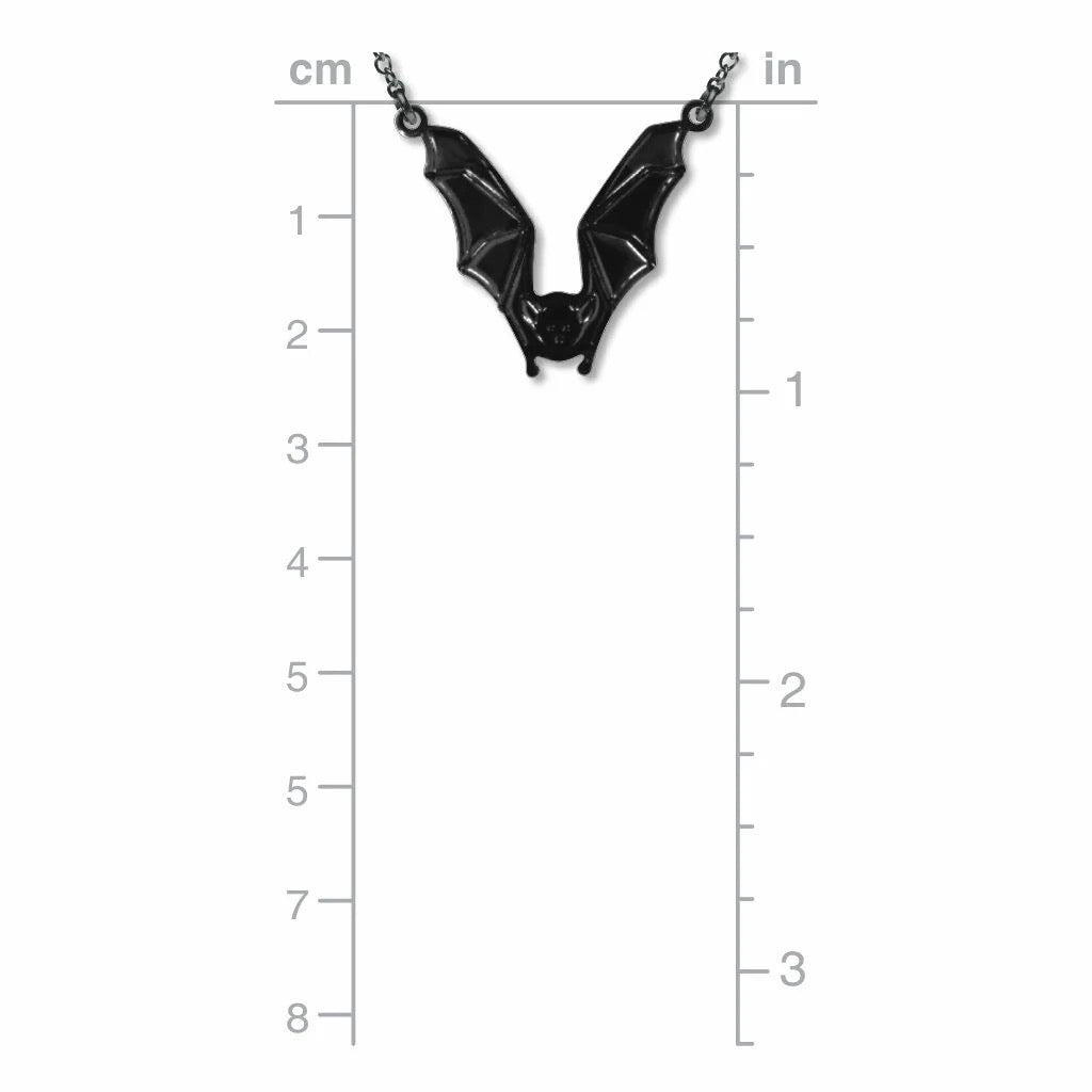 Black bat-shaped pendant on a chain with measurement scale in centimeters and inches.