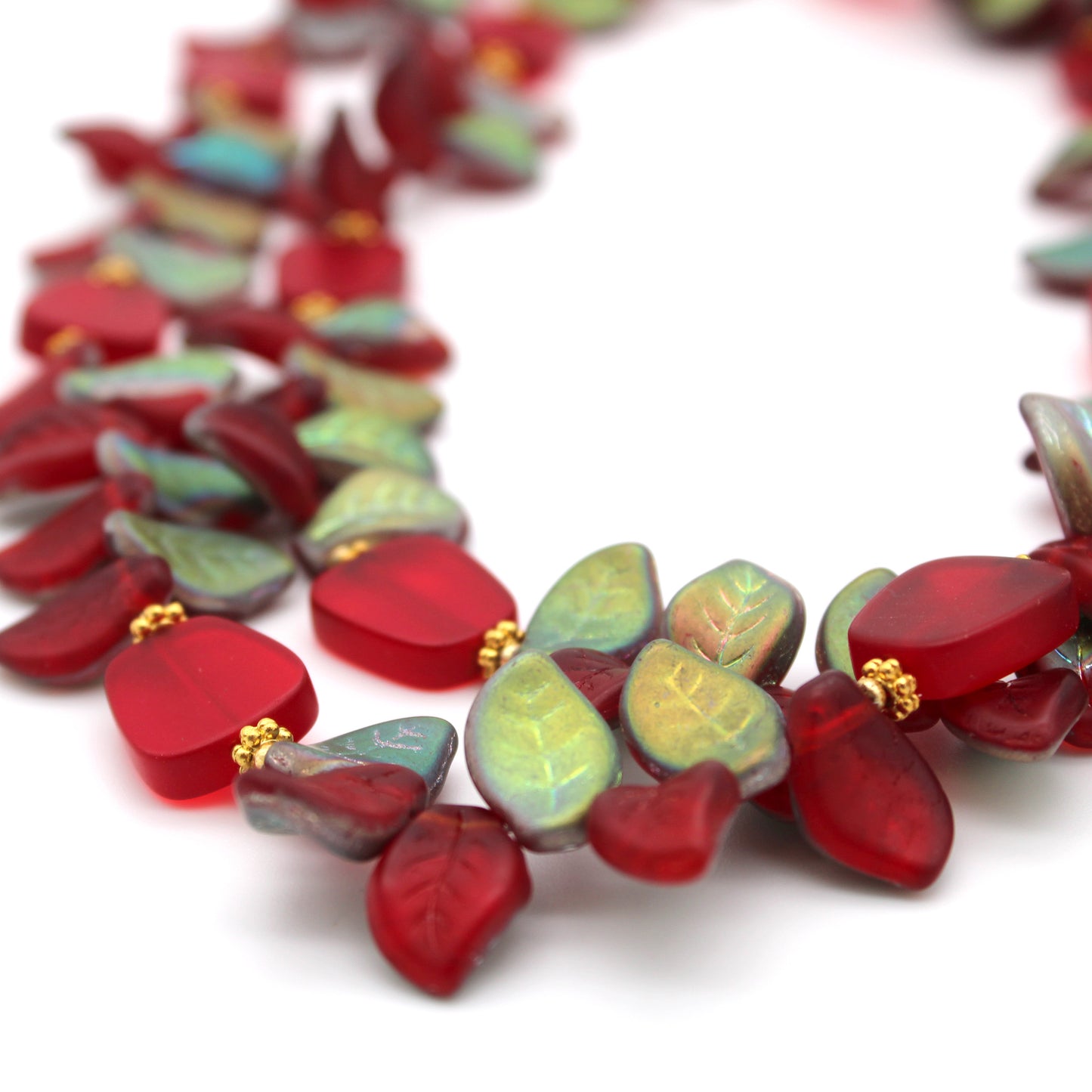 Necklace with red and green leaf-shaped beads on a white background