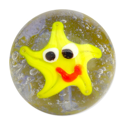 Yellow star-shaped marble with a smiley face on a transparent sphere with bubbles