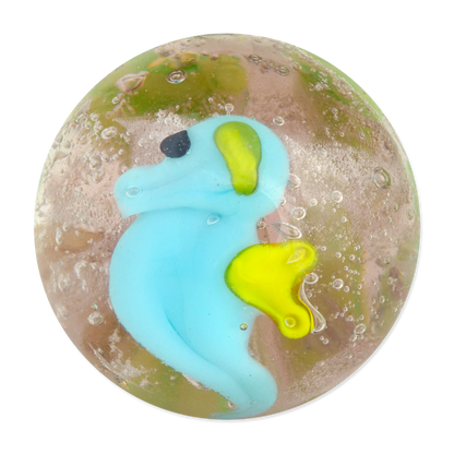 Marble with a blue and yellow seahorse embedded inside on a white background