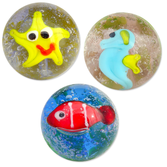 Three colorful marbles with starfish, fish, and seahorse designs on a white background.