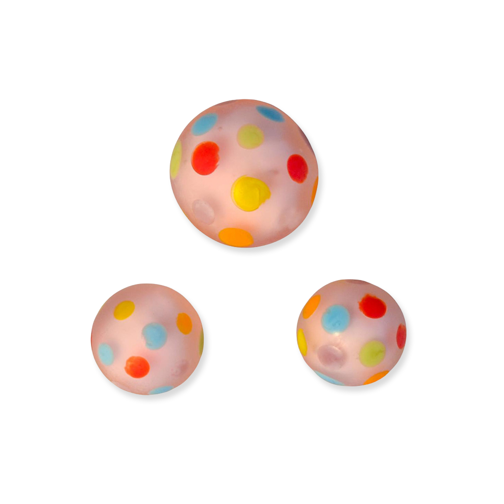 Three colorful polka dot glass marbles on a white background