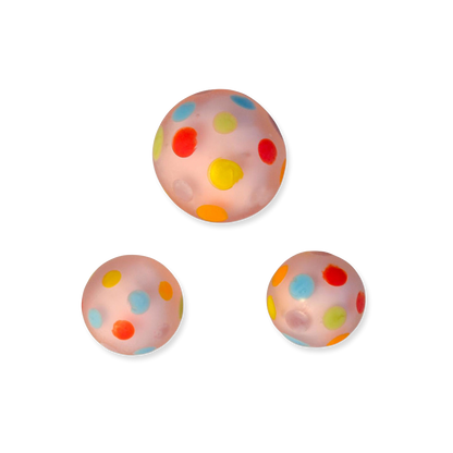 Three colorful polka dot glass marbles on a white background
