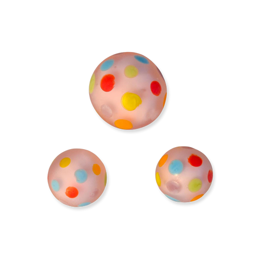 Three colorful polka dot glass marbles on a white background