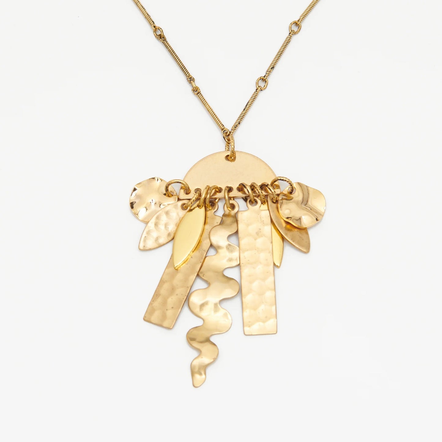 Abstract shapes made of golden brass suspended from a semi-circular shape.