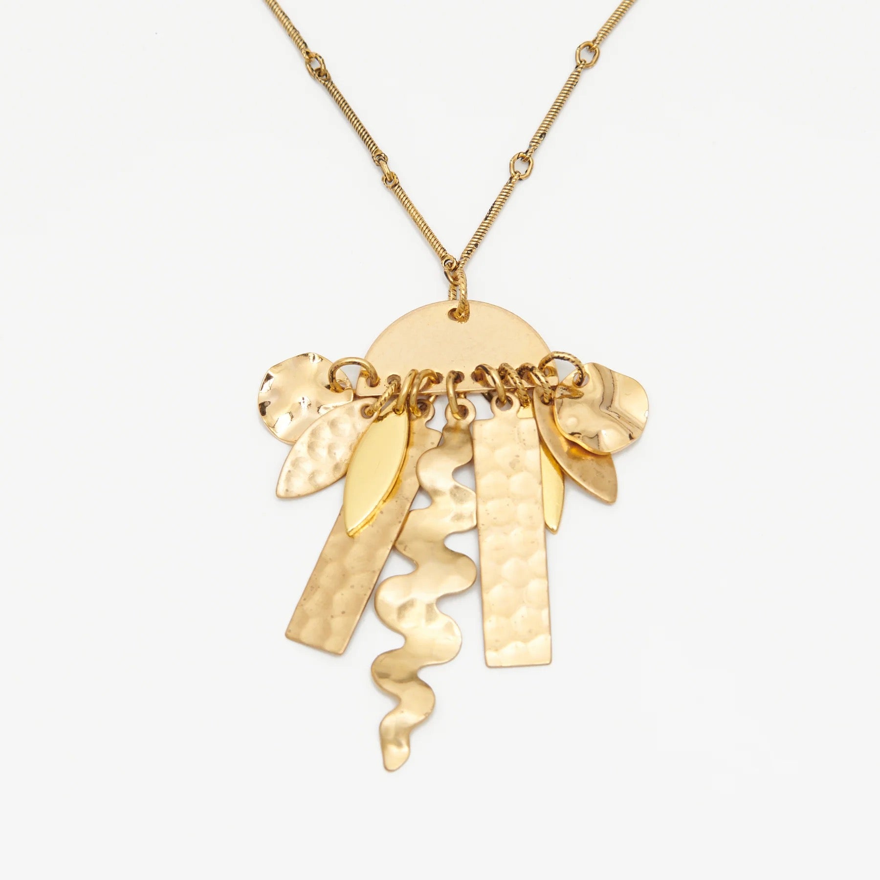 Abstract shapes made of golden brass suspended from a semi-circular shape.