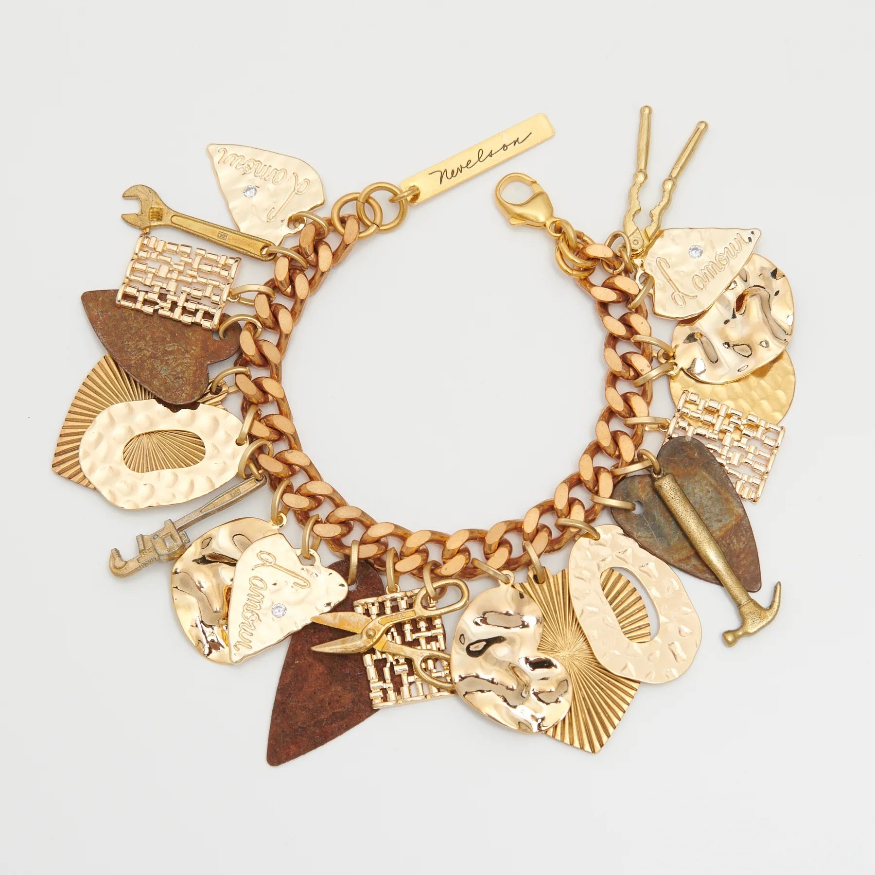 Gold charm bracelet with various intricate charms on a light gray background