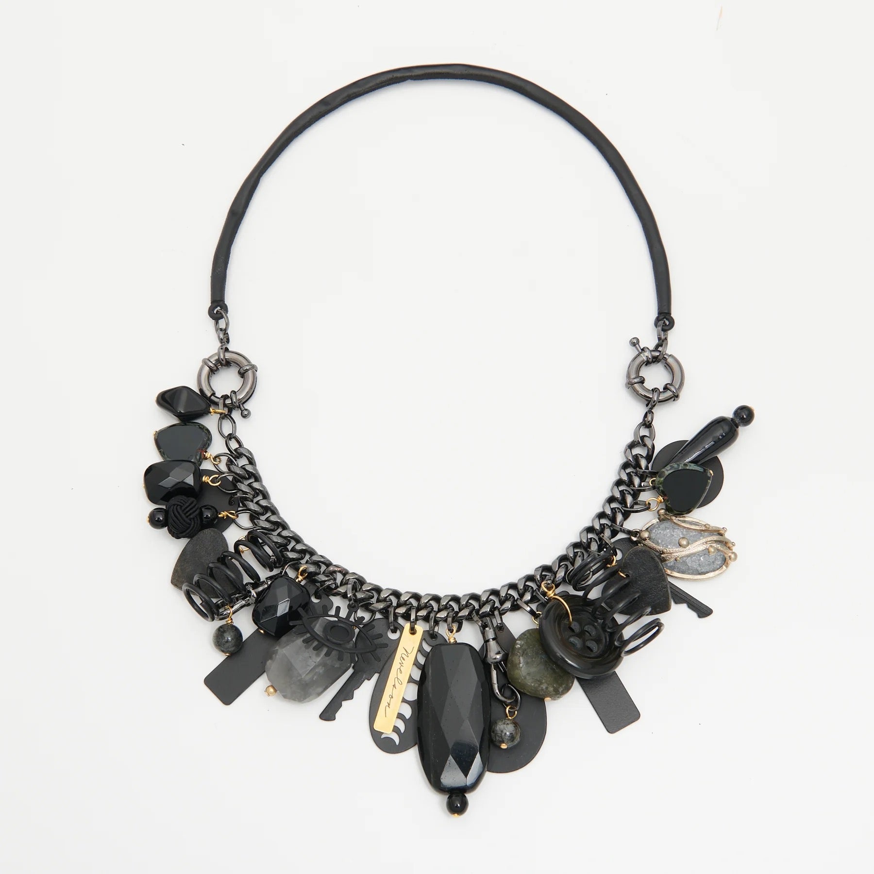 Black and gold necklace with various beads on a white background