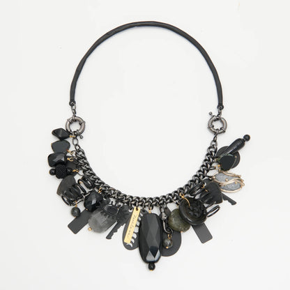 Black and gold necklace with various beads on a white background