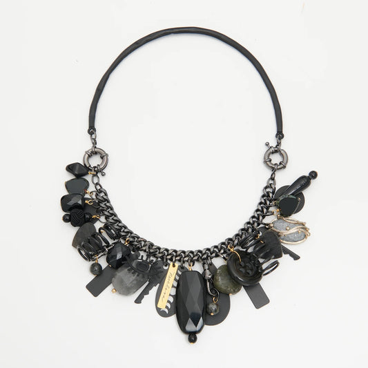 Black and gold necklace with various beads on a white background