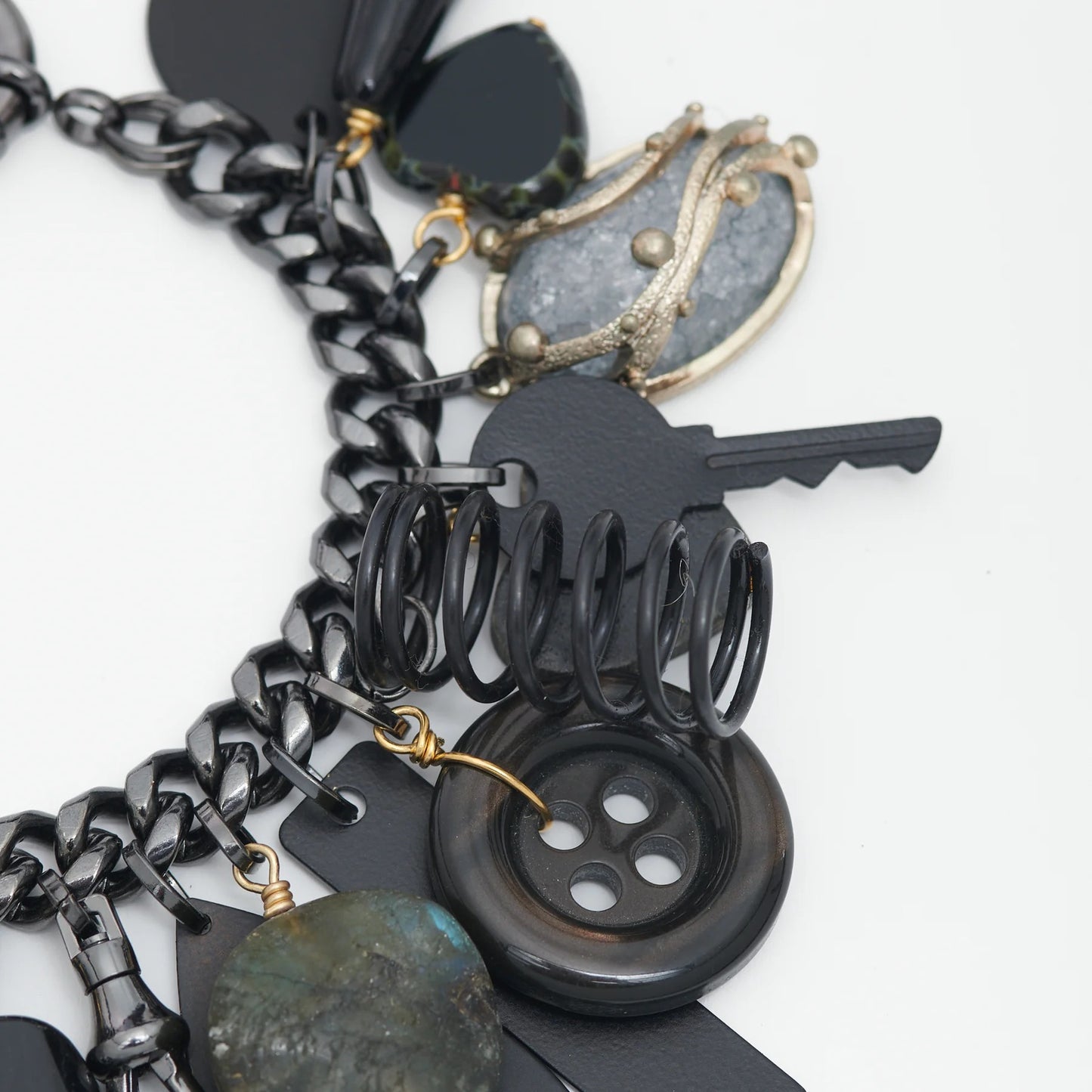 Close-up of a black and silver charm bracelet on a white background
