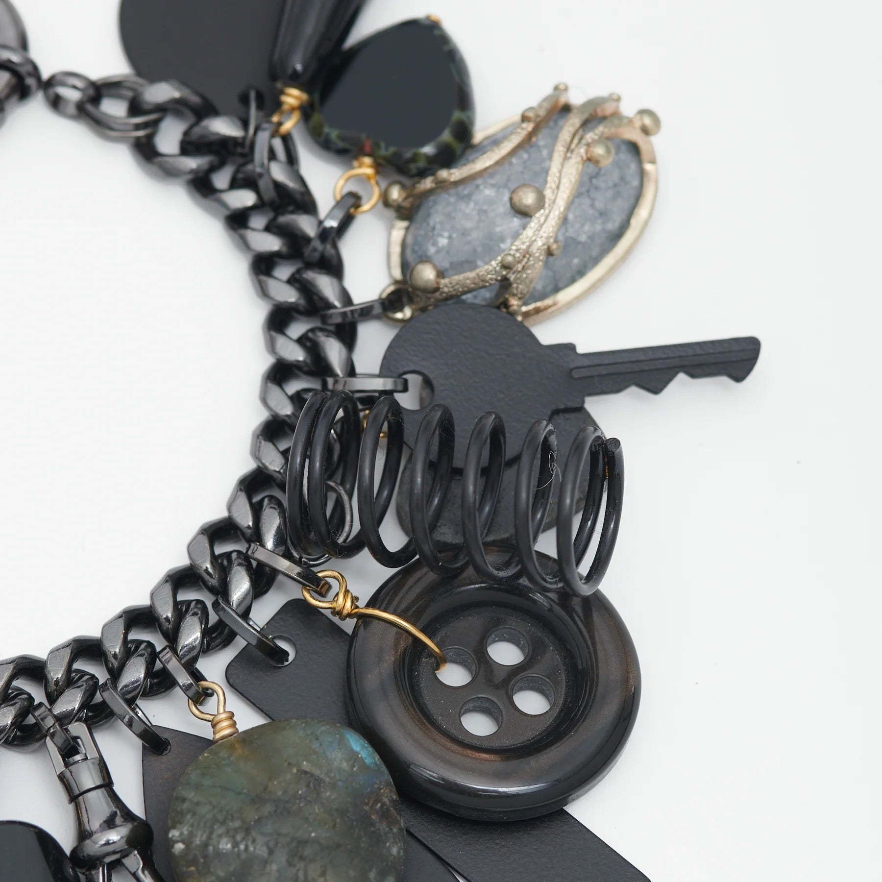 Close-up of a black and silver charm bracelet on a white background