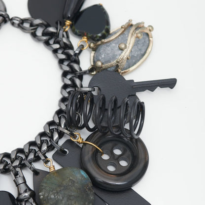 Close-up of a black and silver charm bracelet on a white background