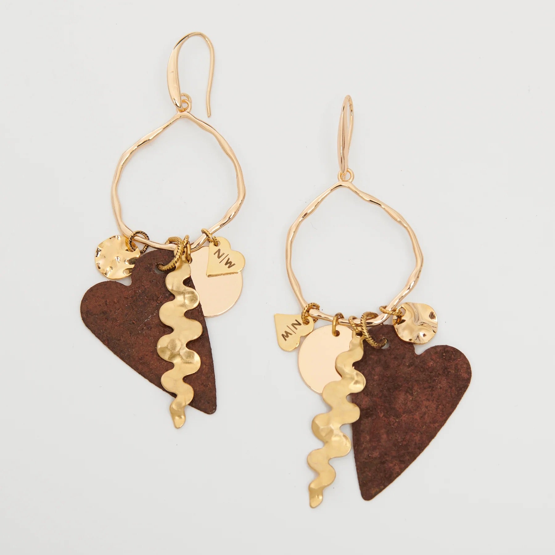 Pair of gold and brown heart-shaped earrings on a light gray background