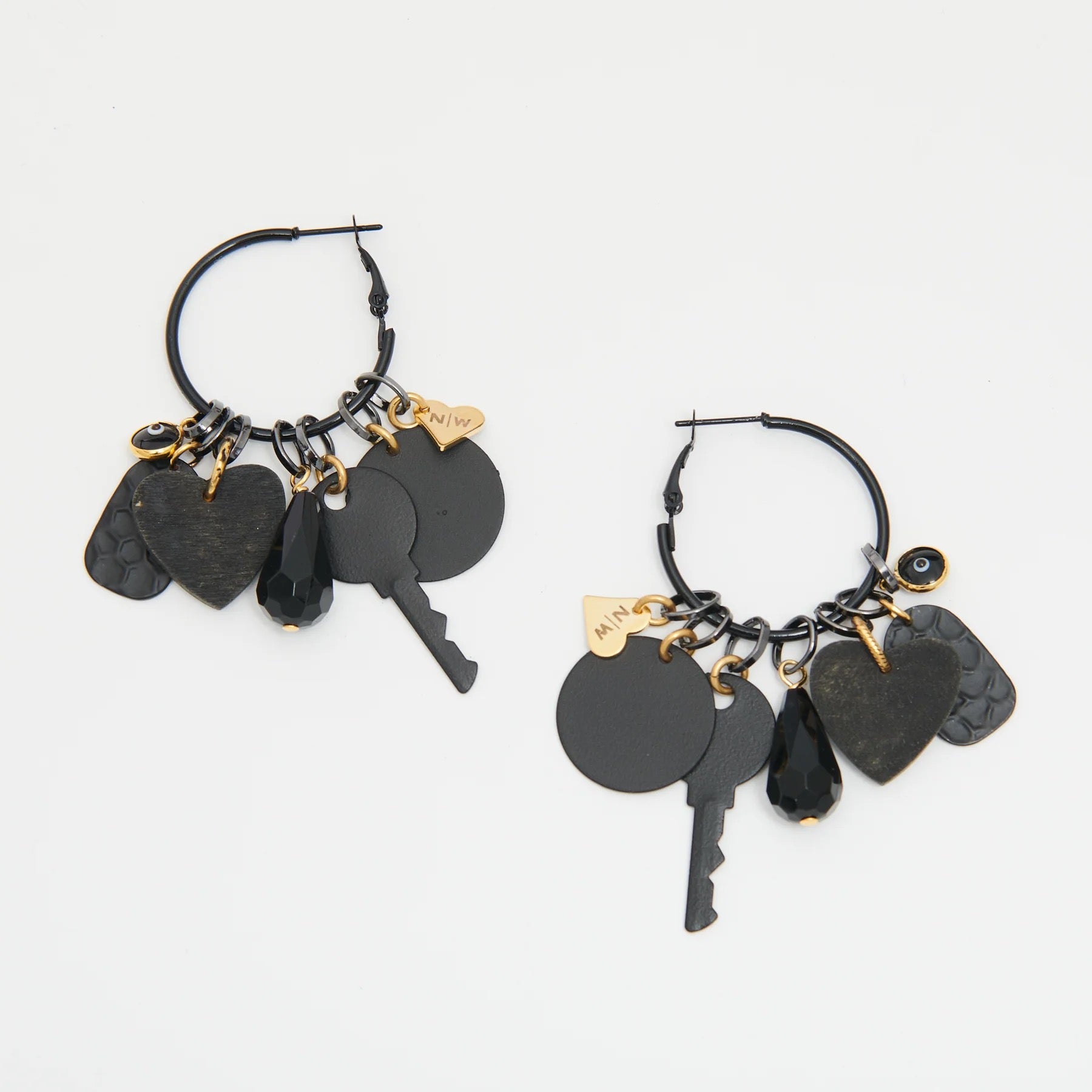 Black hoop earrings with key and heart charms on a white background