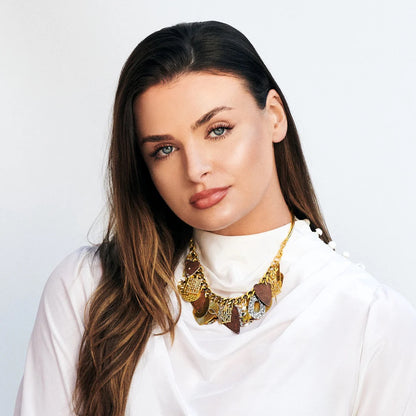 Woman wearing a gold necklace with a white background
