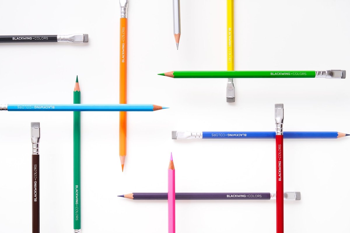 Collection of colored pencils and brushes on a white background