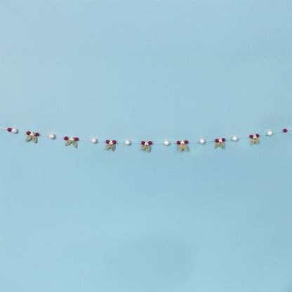 Decorative string with mistletoe and berries on a light blue background