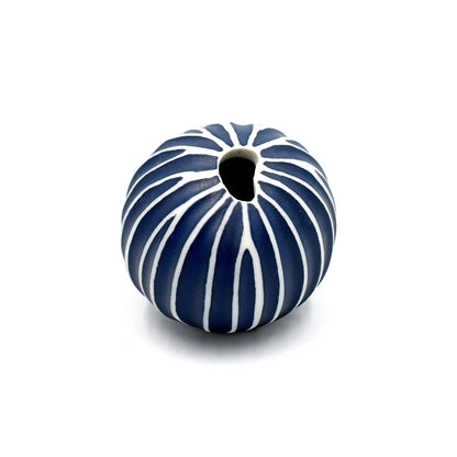 Ceramic vase with blue and white striped pattern on a white background