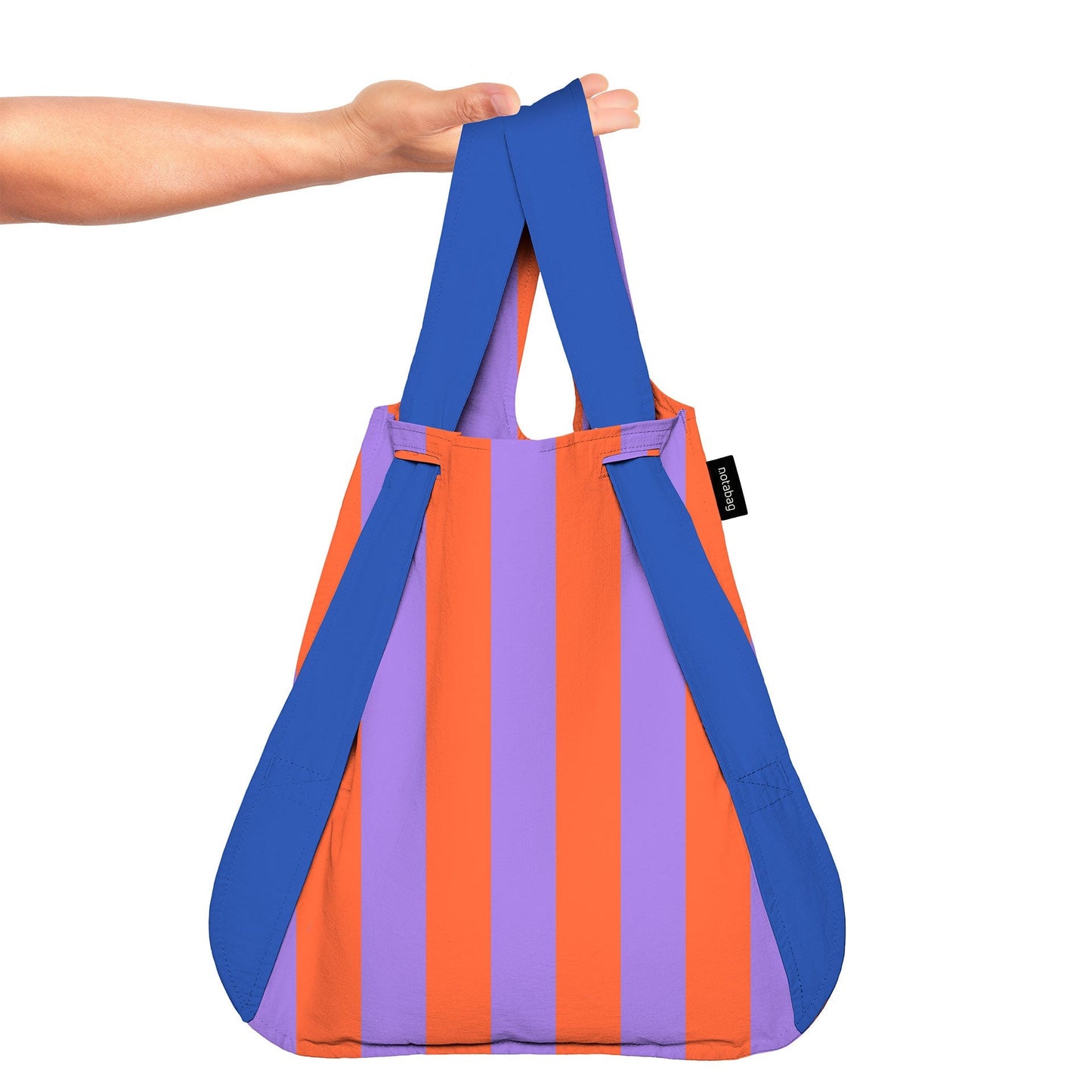 Colorful striped bag with blue straps held by a hand on a white background