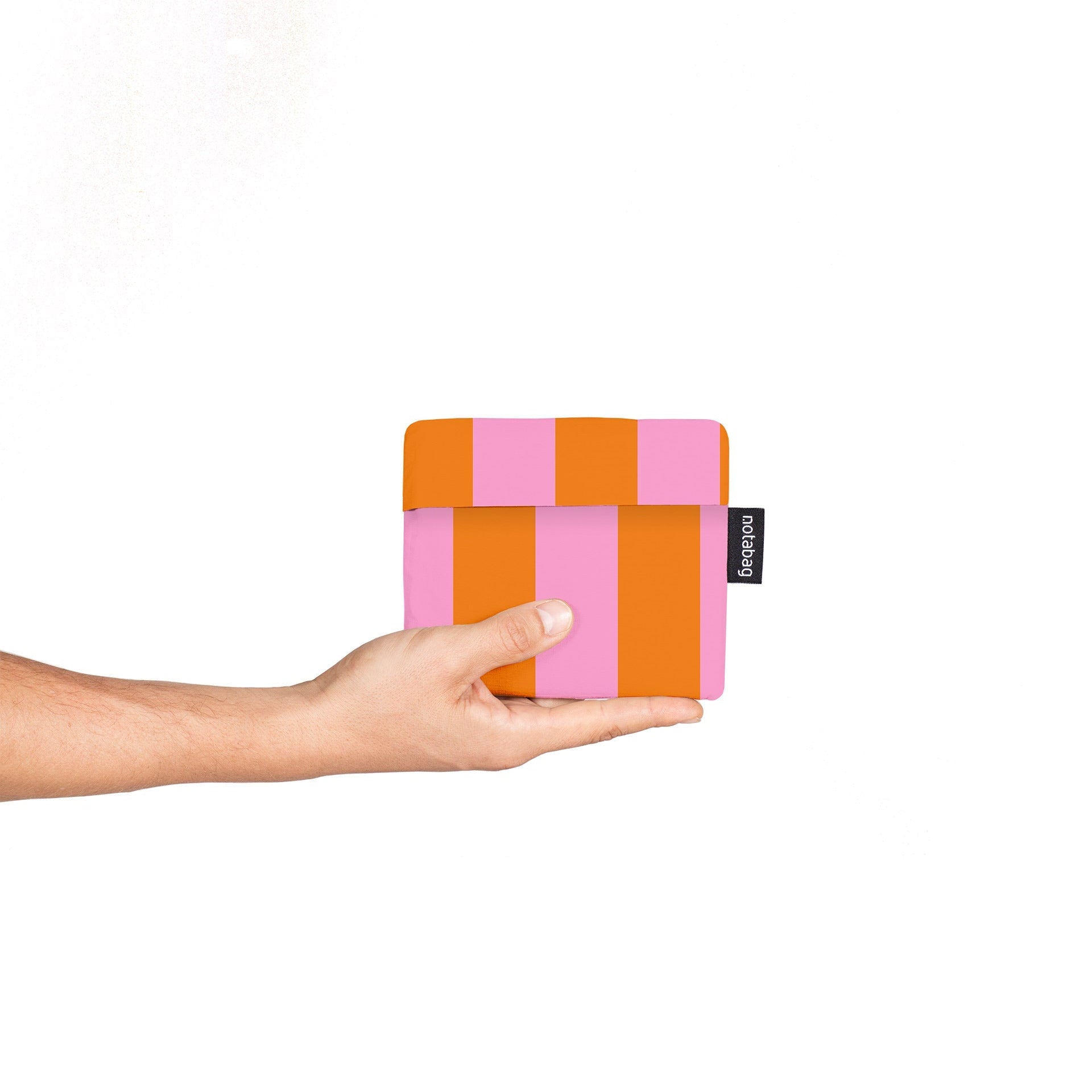 Hand holding a colorful striped pouch with a visible brand logo on a white background