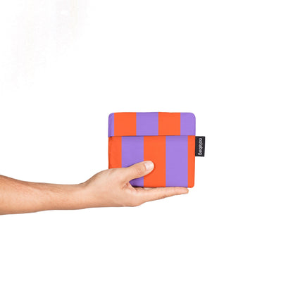 Hand holding a colorful wallet against a white background