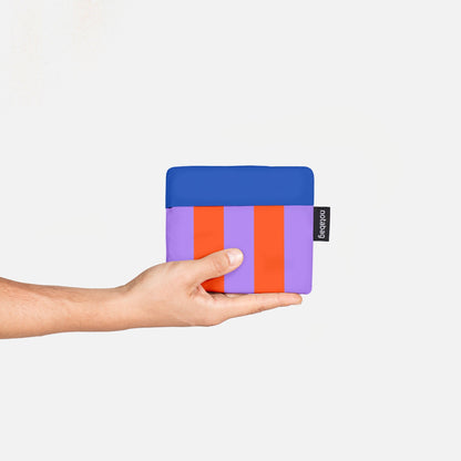 Hand holding a colorful wallet against a white background