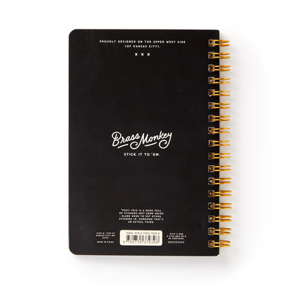 Black notebook with gold spiral binding and 'Brass Monkey' branding on a white background