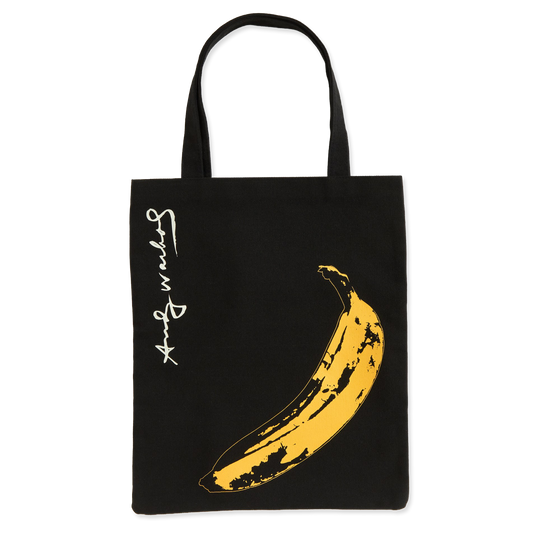 Black tote bag with yellow banana graphic and 'Andy Warhol' signature on a white background