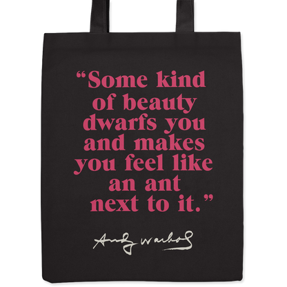 Black tote bag with a quotation by Andy Warhol printed in pink.