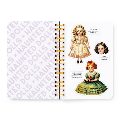 Notebook with vintage doll illustrations and text on a white background