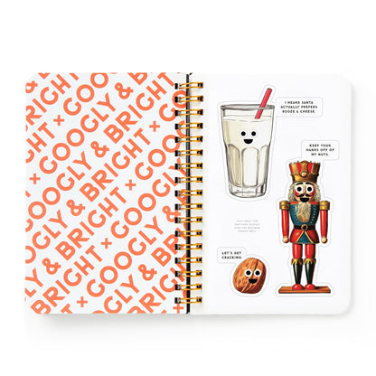 Notebook with orange text pattern and a Christmas-themed illustration on a white background