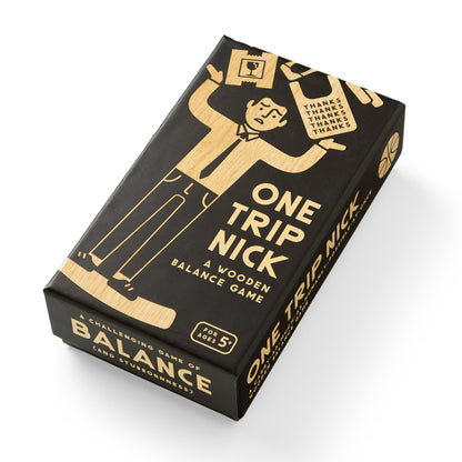 Black and gold box of 'One Trip Nick' wooden balance game on a white background
