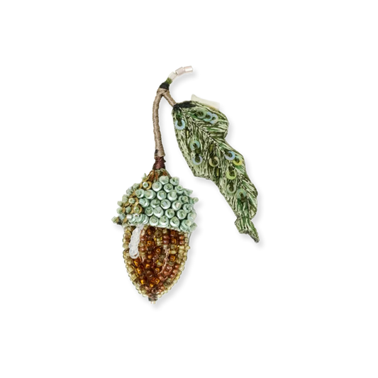 Decorative acorn and leaf brooch on a white background