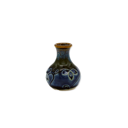 Small ceramic vase with blue glaze on a white background
