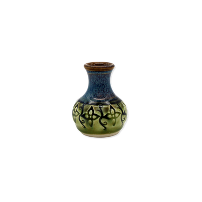 Ceramic vase with blue and green glaze and black patterns on a white background