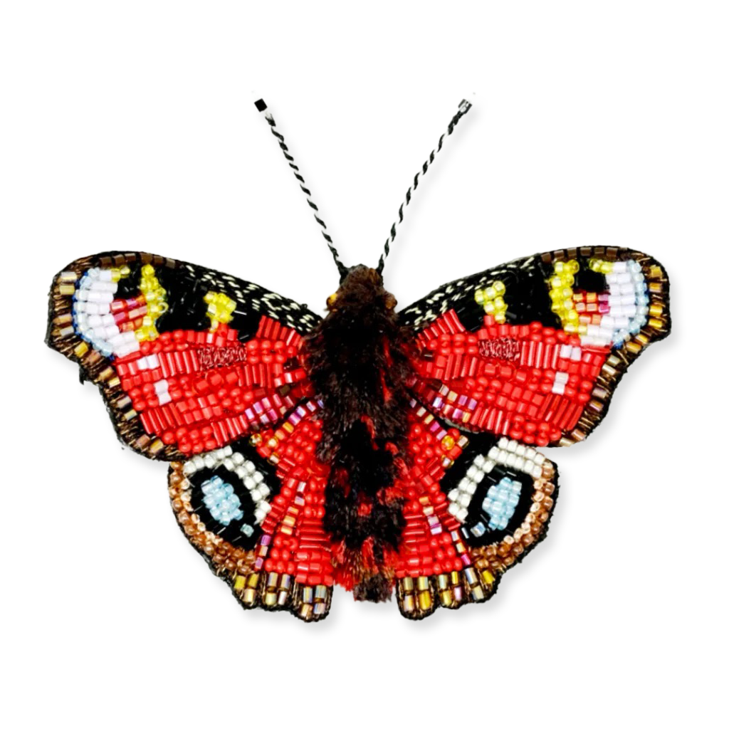 Butterfly-shaped beaded brooch on a white background