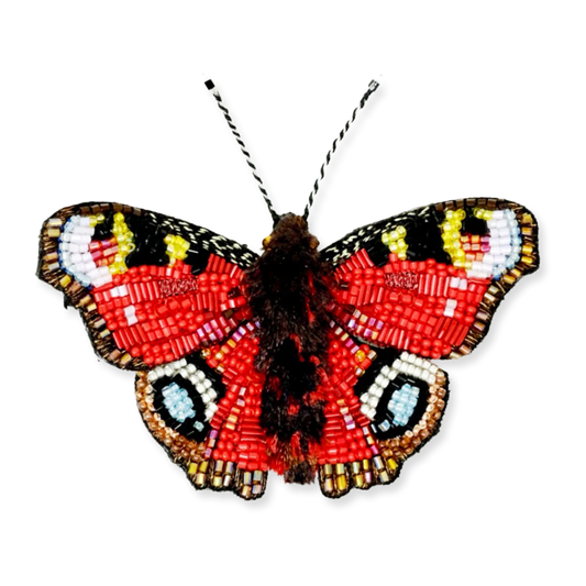 Butterfly-shaped beaded brooch on a white background
