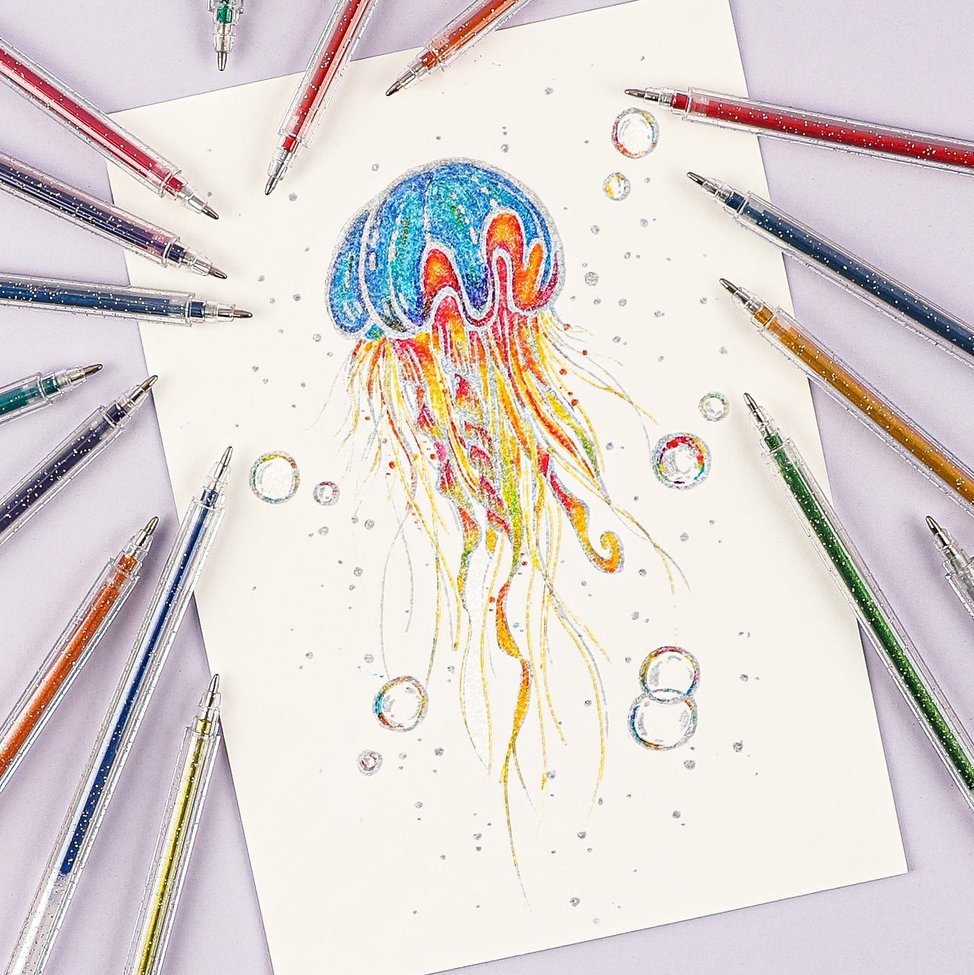 Colorful jellyfish illustration on a piece of paper surrounded by colored pens.
