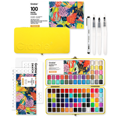 Grable watercolor set with watercolor pans, brushes, and swatch book on a white background