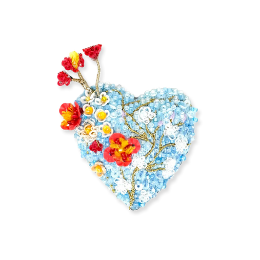 Heart-shaped brooch with floral design on a white background