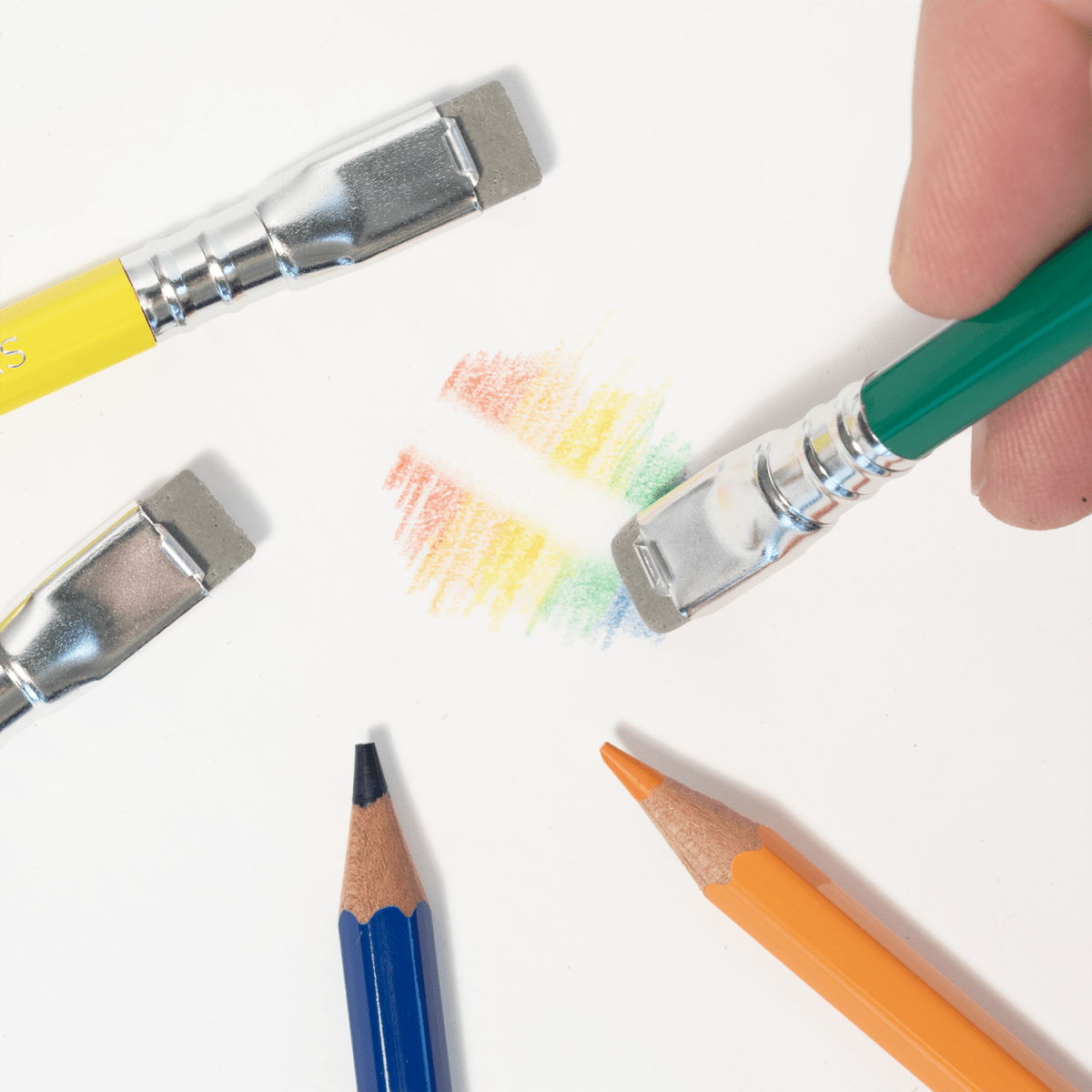 Colorful pencils and paintbrushes with color swatches on a white background