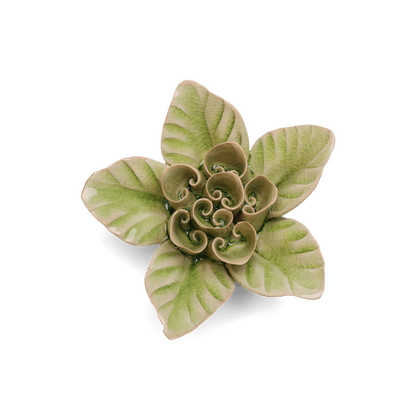 Decorative ceramic flower with green and beige pattern on a white background
