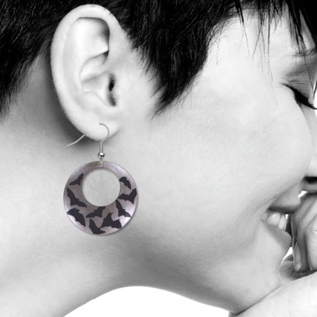 Close-up of an ear wearing a unique earring with a patterned design.