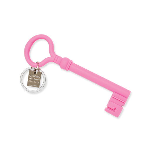 Pink key-shaped keychain with a tag on a white background