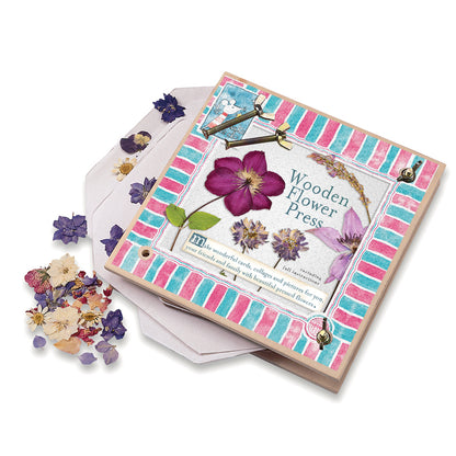 Wooden flower press with colorful design and dried flowers on a white background