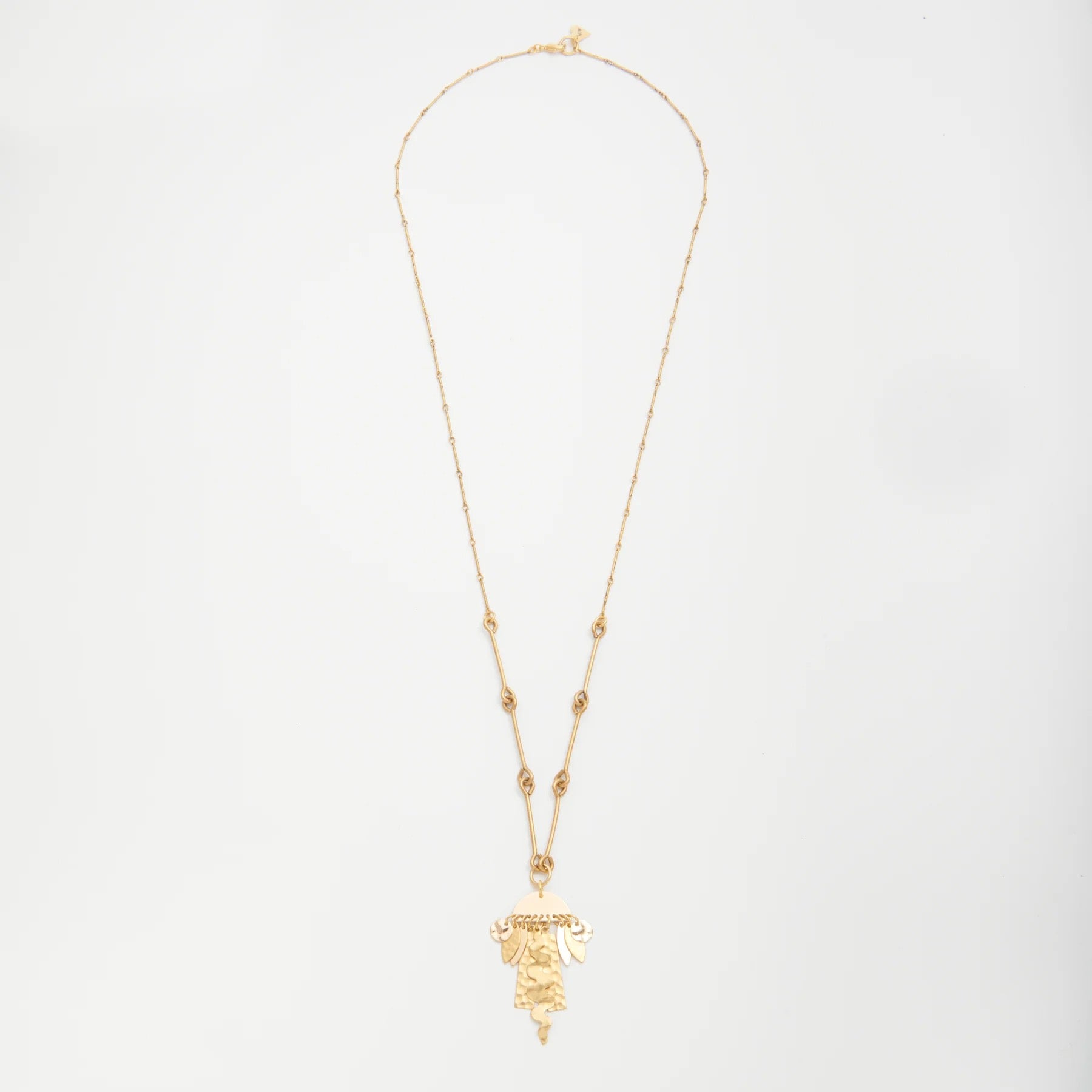 Gold necklace with a pendant on a light gray background