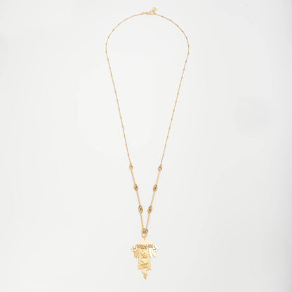 Gold necklace with a pendant on a light gray background