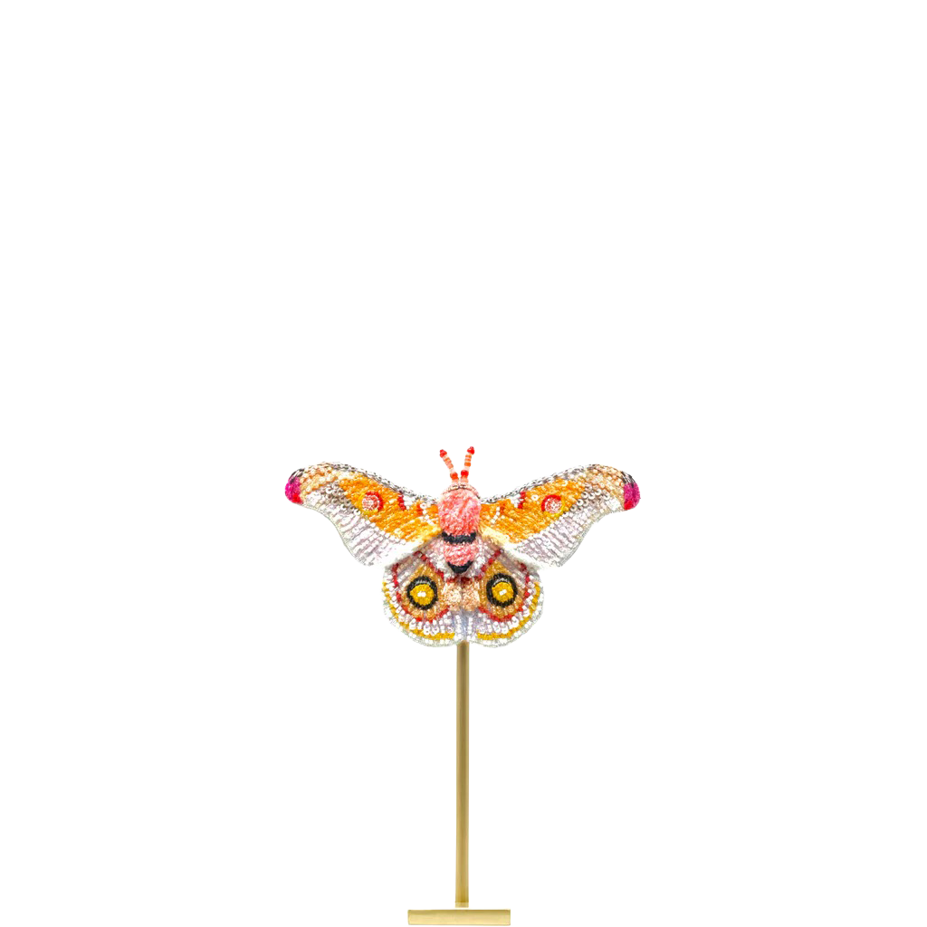 Decorative butterfly sculpture on a stand with a white background